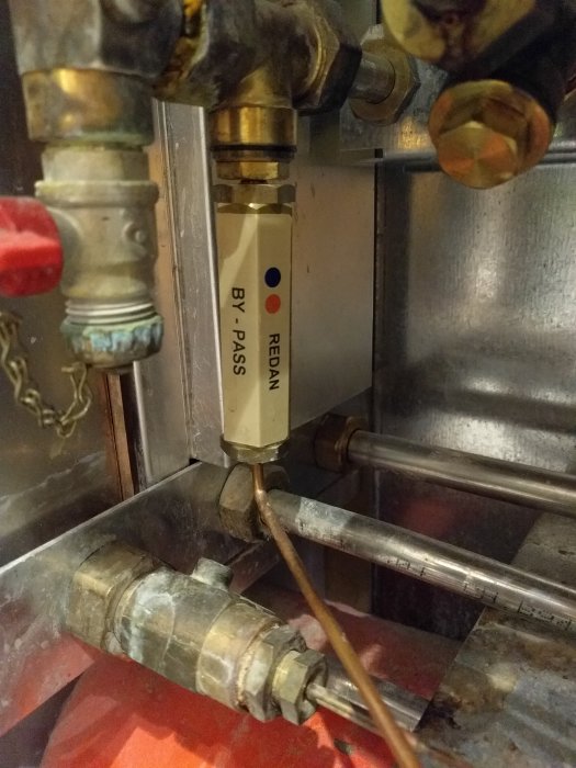 Ventilationssystem med bypass-ventil märkt 'REDAN', omgiven av rör och kopplingar.