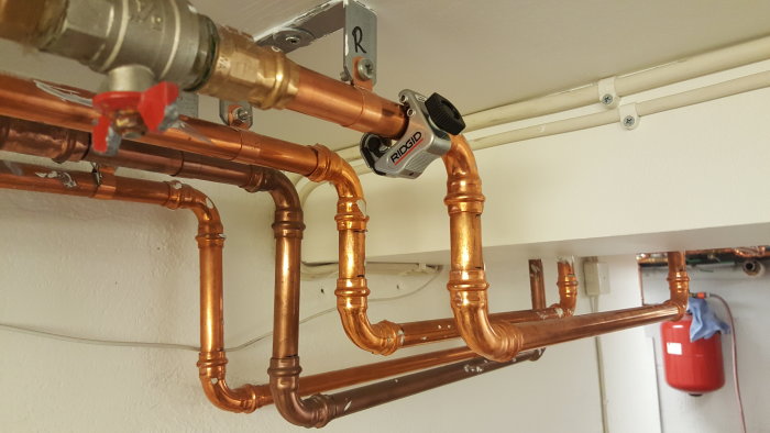 Kopparledningar och rörkopplingar under installation i ett husprojekt.