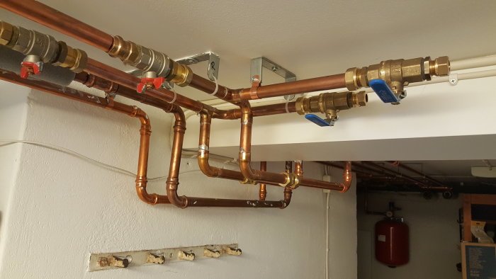 Installation av kopparledningar med reglerventiler på ett expansionskärl i ett pannrum.