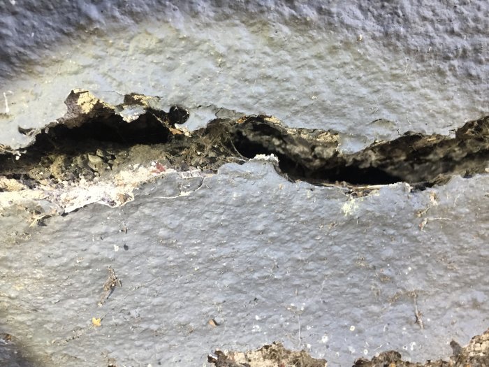 Närbild på en ca 2 cm bred och djup spricka i lecablockens grund.