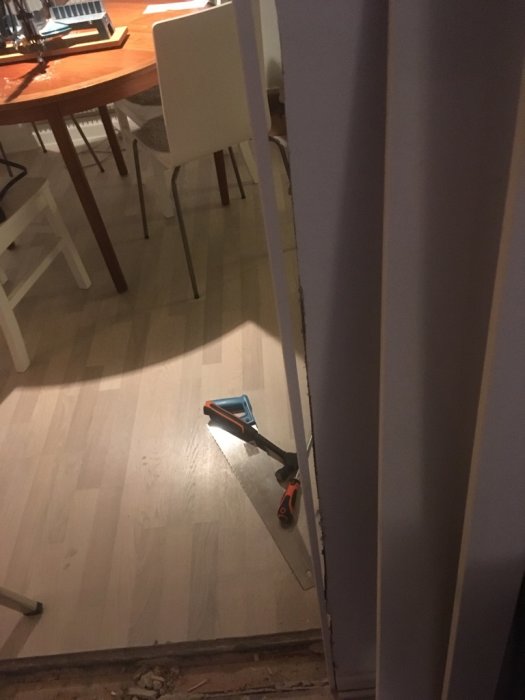 Ojämna väggar vid hörnet där en vägg har rivits, med lister på golvet redo för montering.