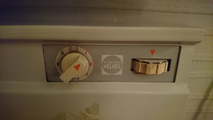Gammalt el-element med inställningsrattar märkta 1-2-3 och temperaturregleringshjul.