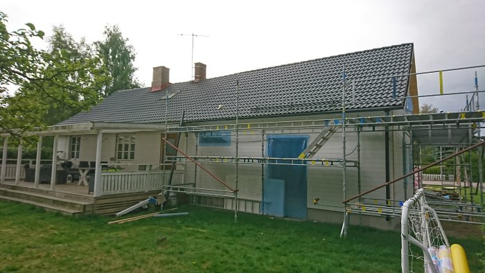 Ett hus med ställningar och nya takpannor installerade på taket.