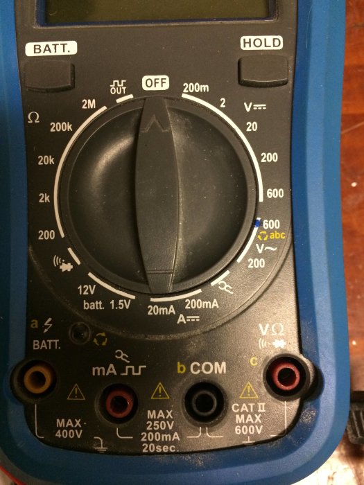 Analog multimeter med inställningsratt och mätuttag märkta COM och mA.