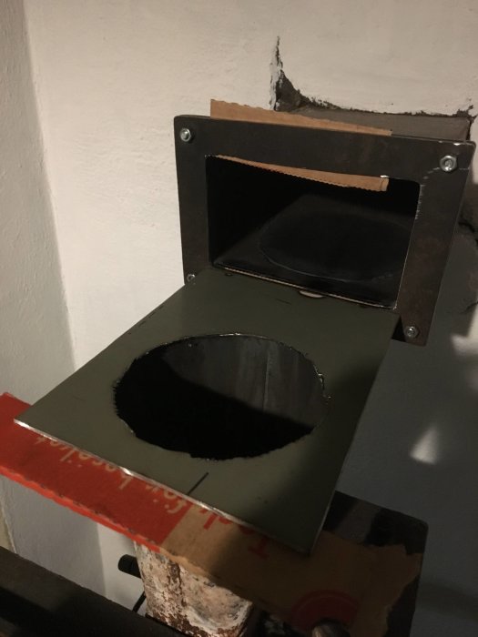 Fläns och bottendel i plåt provmonterade på rökrör med synliga skarvar tätade med vävt glasfiberrep.