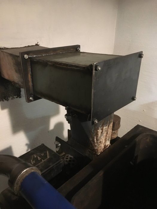 Provmonterad rökrörsfläns i 3mm plåt ansluten till panna, med tätade skarvar och sotlucka.