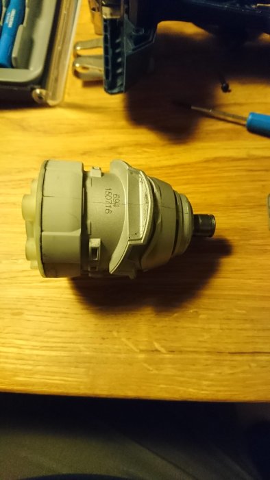 Bosch GDR 18v skruvdragarens gråa helgjutna växelhus på ett träbord, med problem med avbruten adapter.