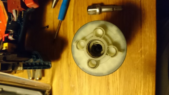 Avbruten bits-hållare i växelhuset av en Bosch GDR 18v med maskindelar i bakgrunden.