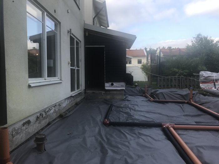 Husgrund med nylagt dränering och dagvattensystem vid en villa under renovering.