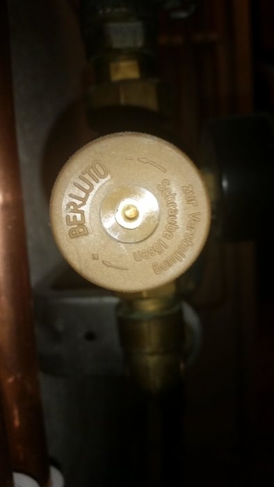 En vattenventil märkt "BERLUTO" med inställningsratt och mässingsdetaljer på kopparledningar.
