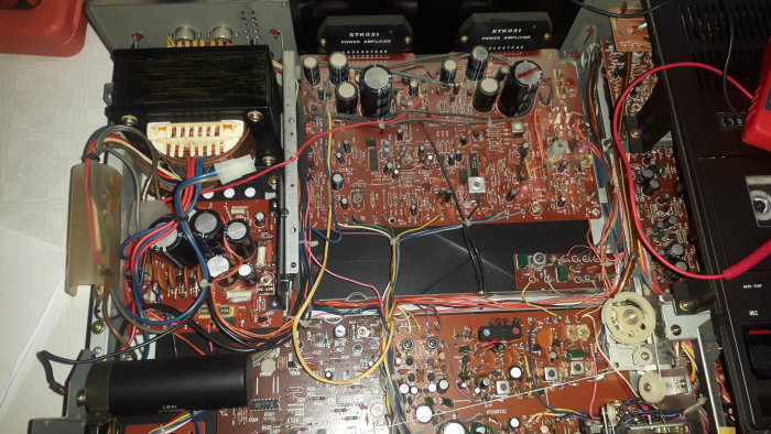 Inre elektronik av en förstärkare med synlig säkring och kondensatorer, misstänkt trasig komponent.