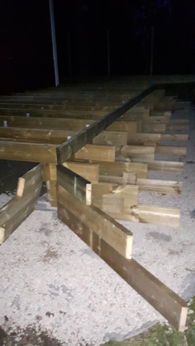 Trätrappa under konstruktion på kvällen med vang i vinkel som behöver fästas.