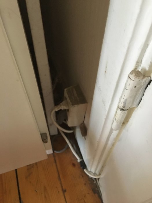 Eluttag med utanpåliggande eldragning i ett hörn nära en vägg som ska rivas.