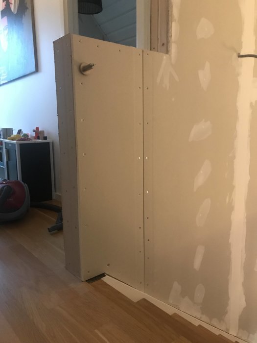 Nyinstallerade gipsskivor i trappan med spacklade skarvar och skruvhuvuden, redo för ytterligare spackling och hörnskydd.