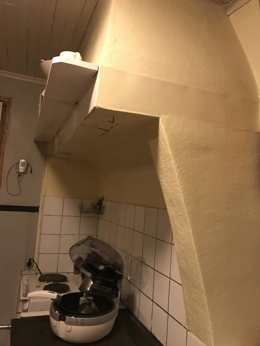 Murad spiskåpa ovanför en köksspis i ett kök under renovering.