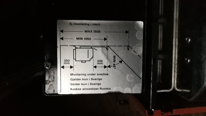 Etikett med installationsmått och instruktioner för montering under snedtak på svenska och finska.