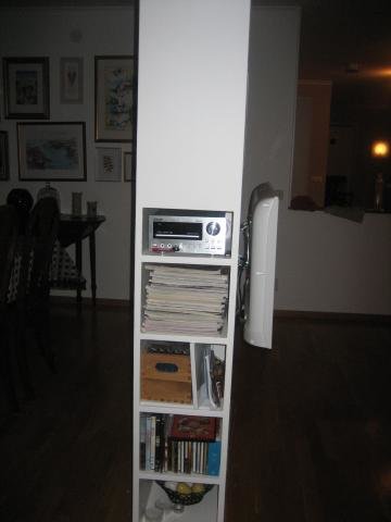 Built-in shelf with stereo, books, and a cable compartment door open.