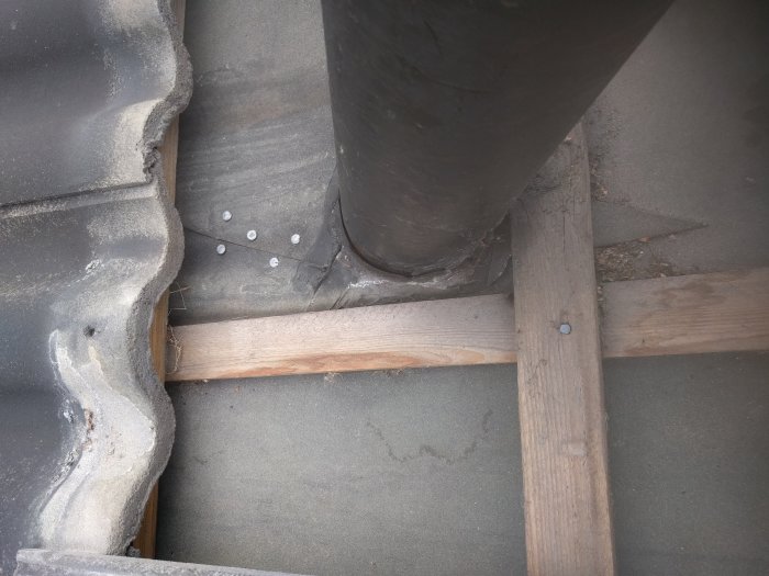 Tak med ventilationsrör genomföring, synliga tätningsförsök och lösa takpannor.