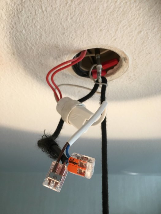 Elektriska kablar och Wago kopplingar som hänger från ett takuttag, redo för inkoppling av lampa.