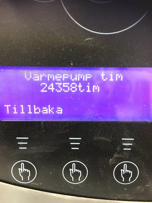 Digital display som visar drifttimmar för värmepump, 24358 timmar, med knappar för navigation under.