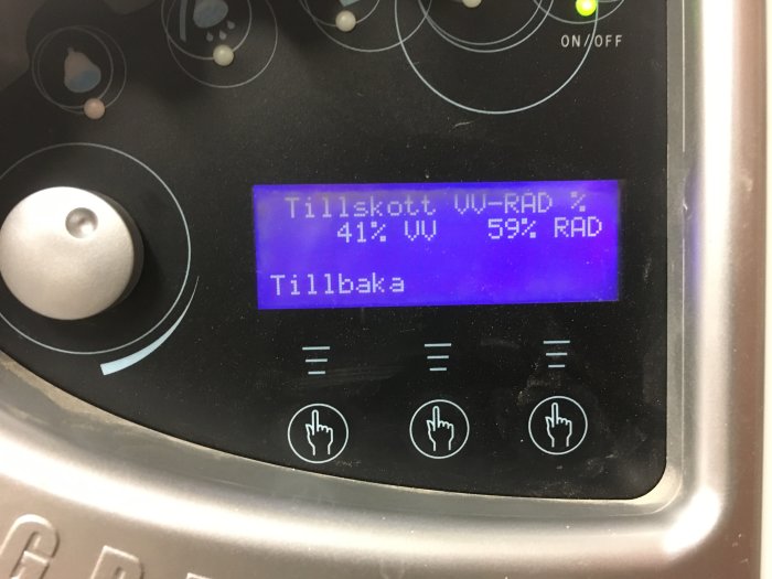 Digital display på en enhet visar "Tillskott. VV 41% RAD 59%" och knappar med pekfingergester.