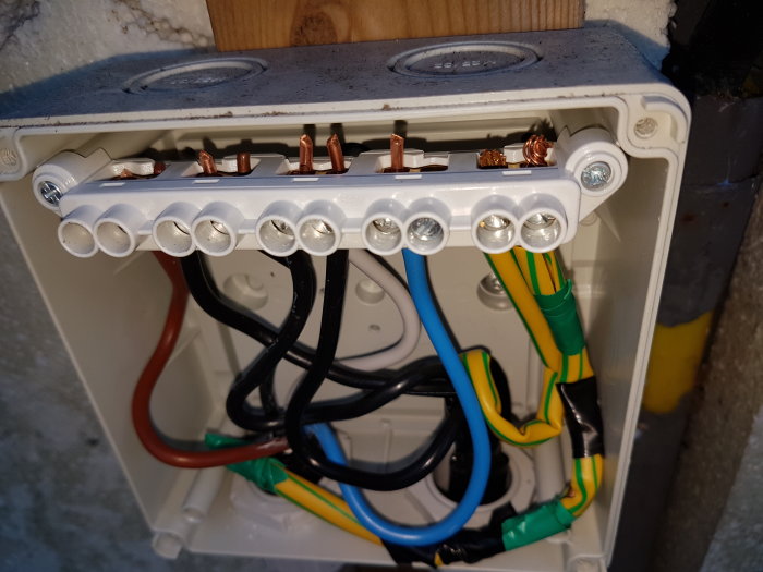 Elcentral med öppet lock som visar 5- och 4-ledarkablar anslutna till klembräda.