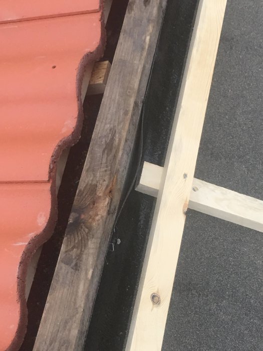 Tak med äldre nockbräda utan underlagspapp och ny läkt vid nock på tillbyggnad.