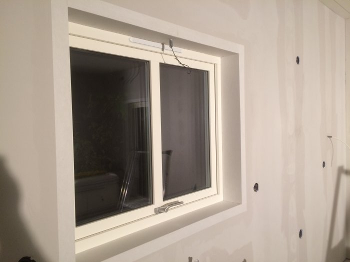 Nymålat fönster med släta karmar redo för vidare renovering av väggarna.