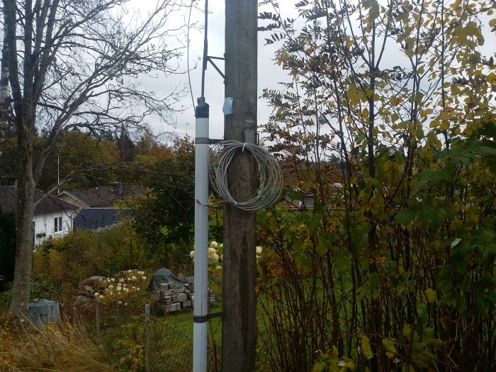 En upprullad ledning hängande på en stolpe i en trädgård för att minska åskrisk.