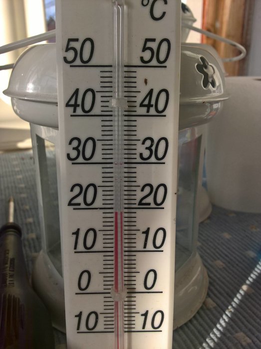 Termometer inomhus som visar hög temperatur för oktober.