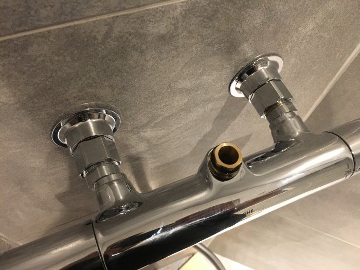 Kromad duschblandare Grohe Vitalio Joy XXL med justerbara excentrar monterad på kakelvägg.