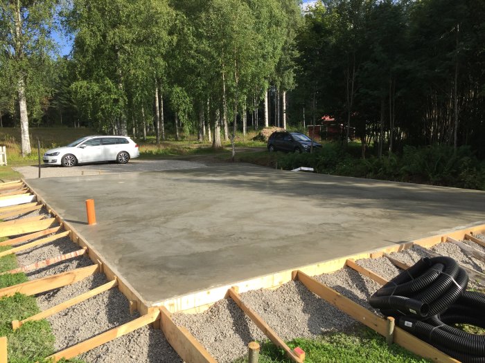 Nyggjuten betongplatta för garage på 96 kvadrat med formar och byggmaterial synliga.