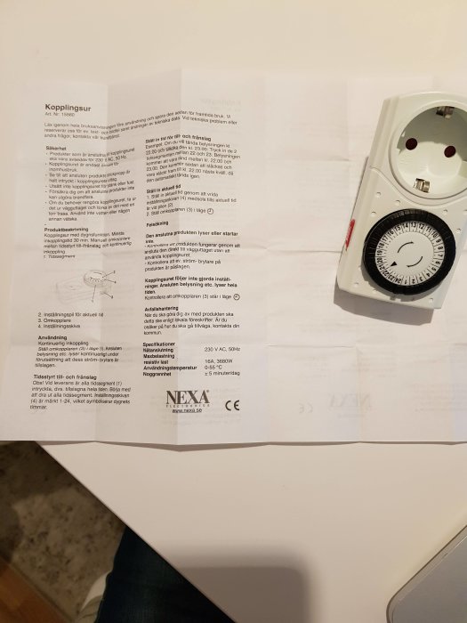 Analog timer och instruktion, inställda pluppar synliga för tidsstyrning av belysning.