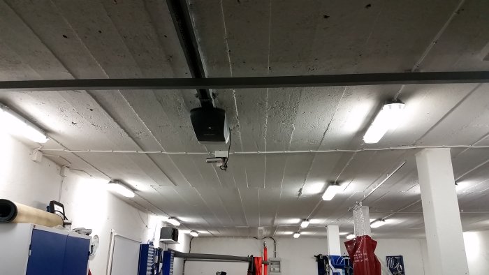 Garagetak med installerad portmotor och synliga kablar som löper längs taket.