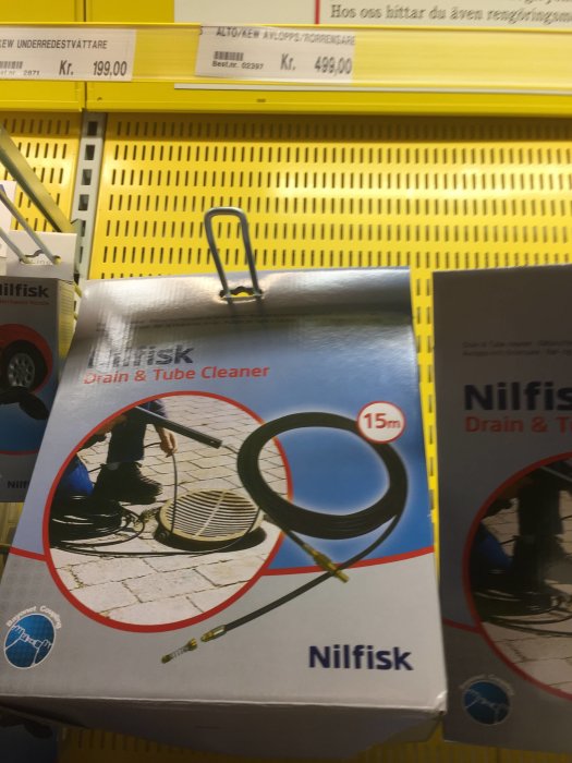 Förpackning av Nilfisk Drain & Tube Cleaner med bild på användning vid avloppsbrunn.