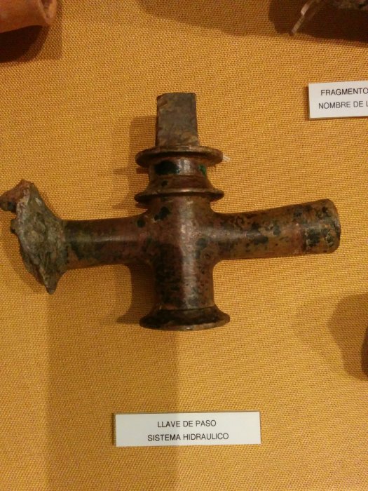 Antik romersk vattenkran i brons, utställd på museum.