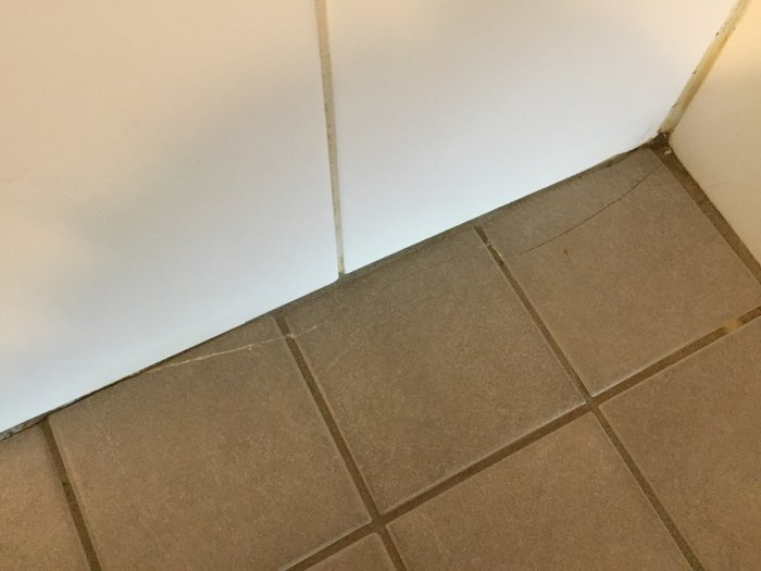 Sprickor i badrumskakel längs med väggen, varje klinker med en likadan ca 3-4 cm spricka.