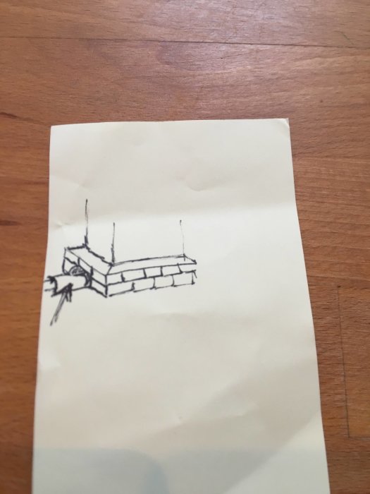 Handritad skiss av skorsten med utstickande kjol och pil som pekar på tunnel för nockpanna.