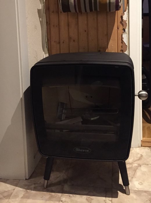 Svart Dovre Vintage 35 kamin står på ett marmorgolv i ett hemmiljö.