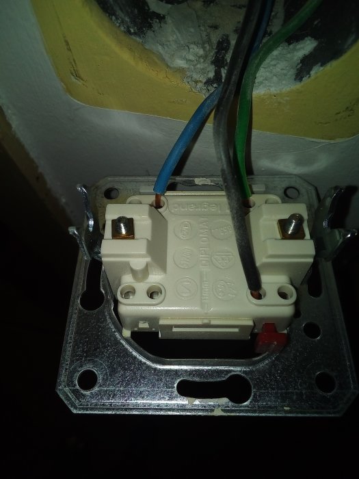 Eluttag under installation med oskyddade kablar och öppet kopplingsutrymme.