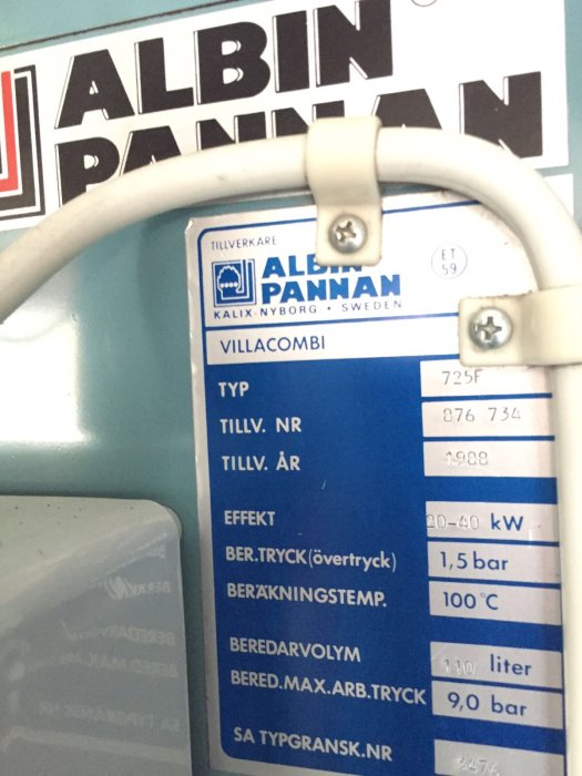 Kretskort synligt i en Albin Villacombi panna, med typbeteckning och specifikationer på etikett.