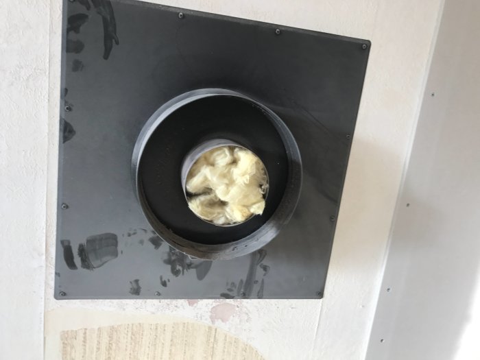 Öppning i vägg för kamin med installerad tilluftskanal och isolering synlig, väntar på kamininstallation.