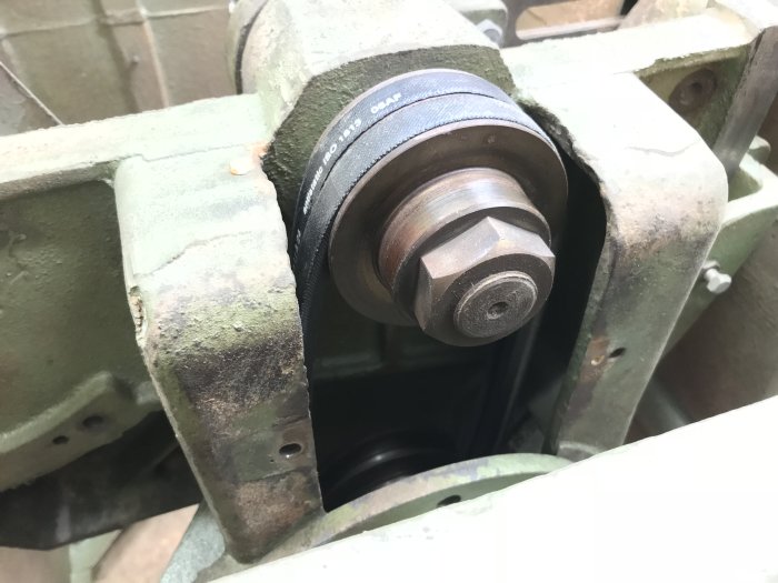 Gamla verktygsmaskinens gjutjärnsstomme med remhjul och utan synliga vibrationer.