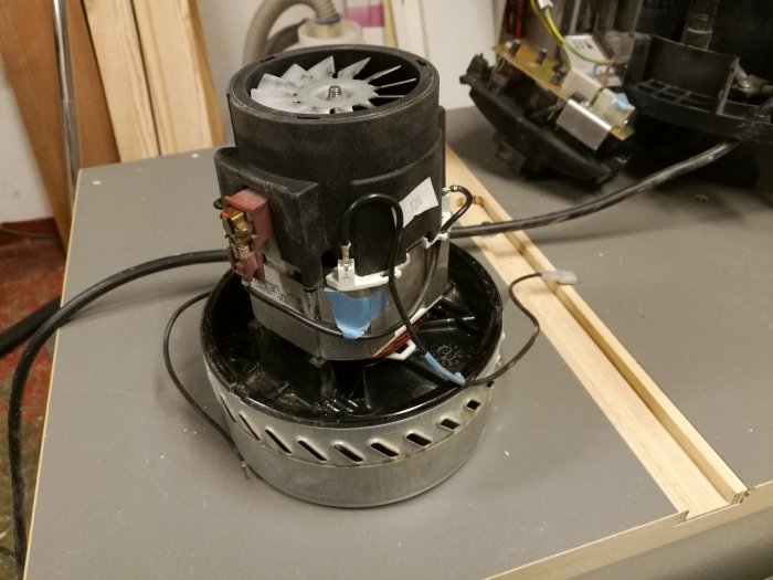 Isärtagen verkstadsdammsugare med synliga motor, kolborstar och kablage.