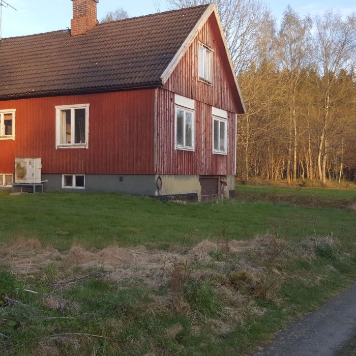 Renovering pågår på ett rött hus med nytt fönster och vägg där garageporten tagits bort.