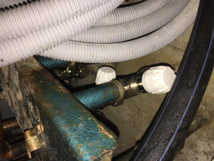 Nya termostatventiler installerade på en rostig radiator.