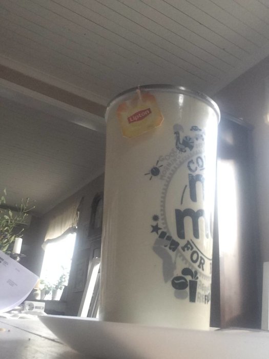 Stor mugg te med Lipton-tepåse framför suddig köksinteriör, troligen uppladdning för renovering.