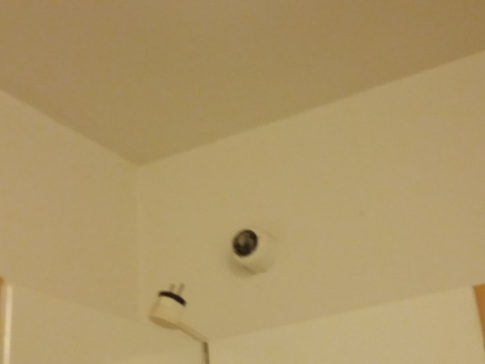 Utdragen kabel från taket ovanför ett väggskåp, indikation på elfel.
