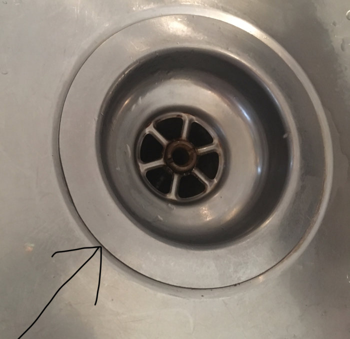 Närbild på en diskho med pil som pekar på en skarv som läcker.