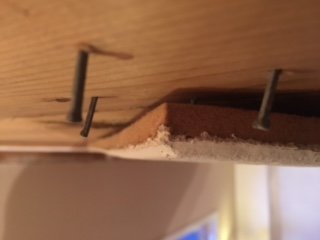 Nahaufnahme einer Eckinstallation von Tretex-Platten mit sichtbaren Befestigungsstiften und einer Holzleiste.
